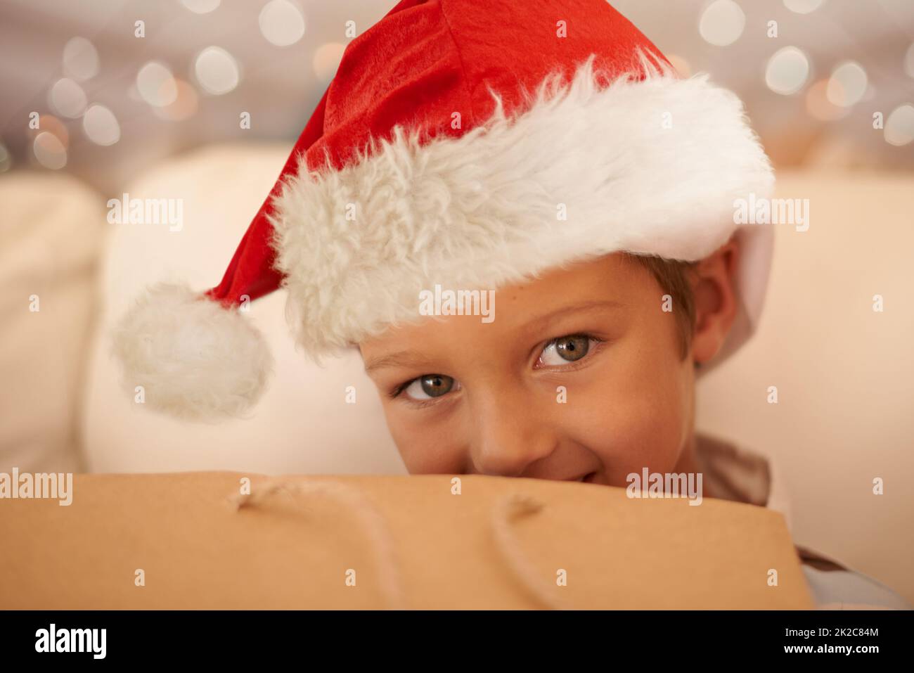 Cant I just open one present Pleeeease.... Cropped portrait of a little boy on Christmas day. Stock Photo