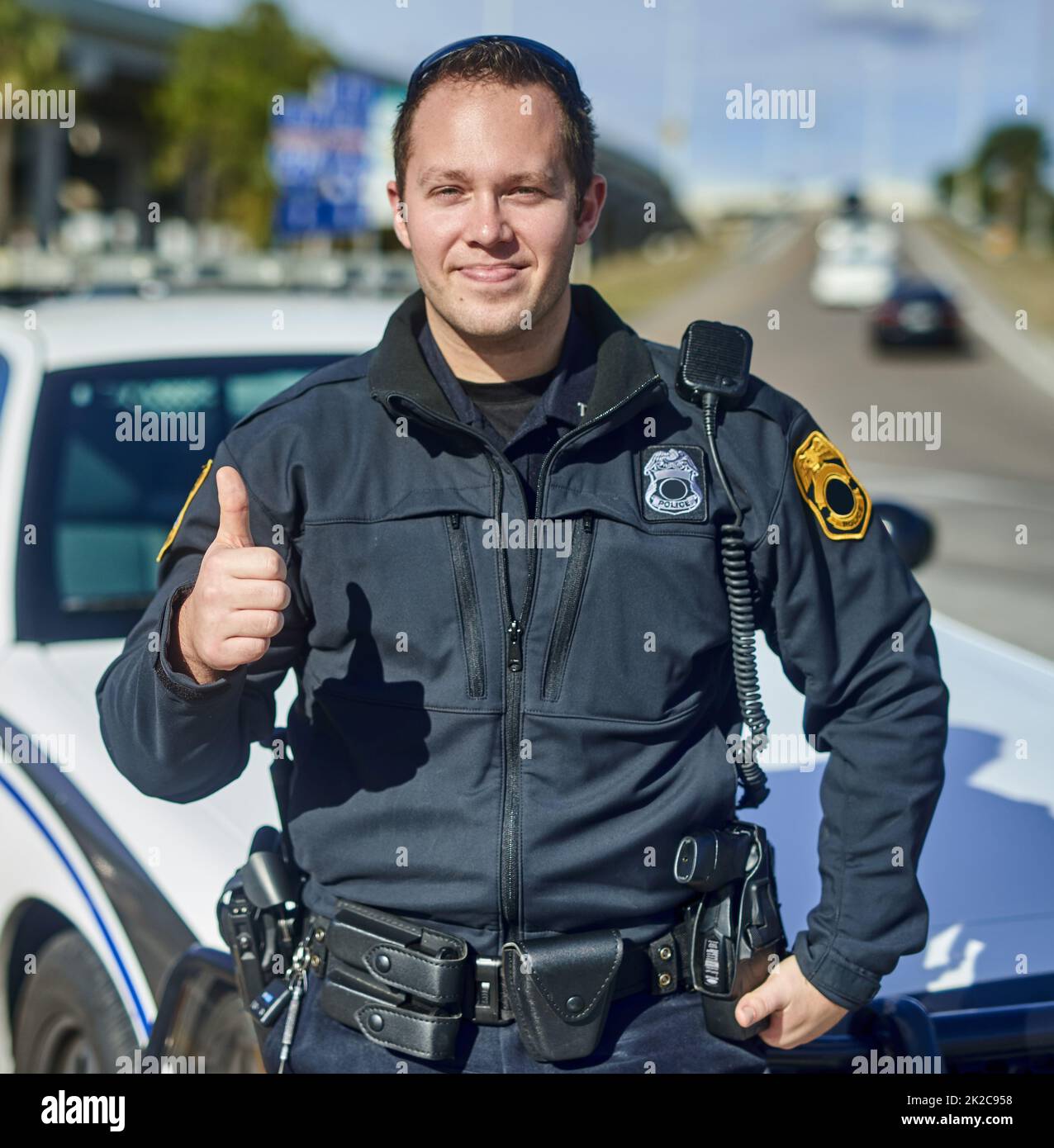 This city is safe. Cropped portrait of a handsome young policeman giving thumbs up while out on patrol. Stock Photo