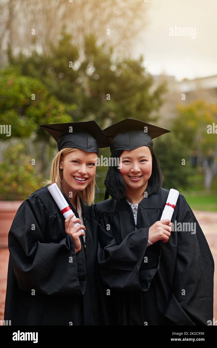 Were ready for our next adventure. Shot of two college graduates holding their diplomas. Stock Photo
