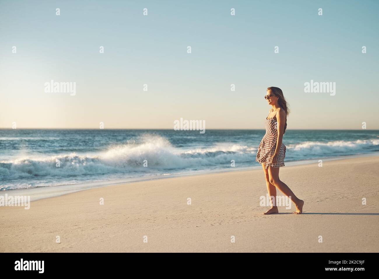 Sometimes the beach is all you need. Shot of a young woman taking a
