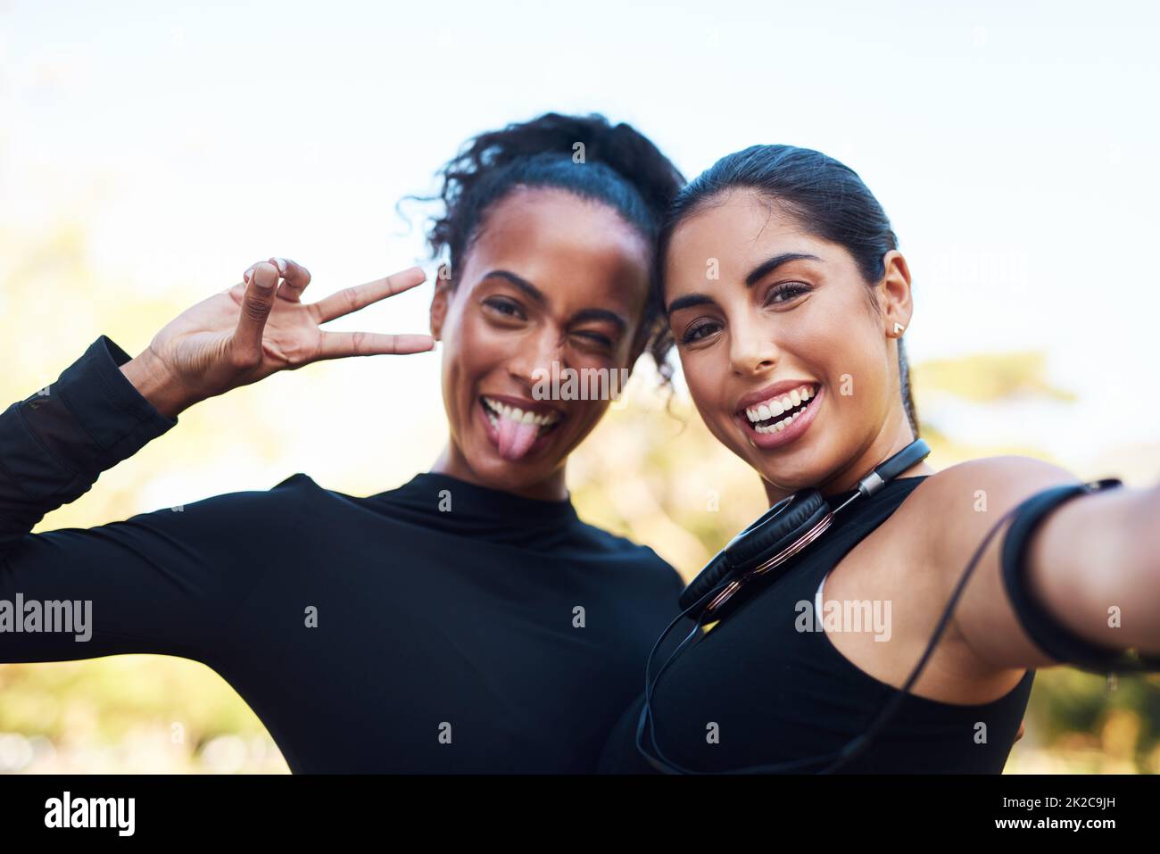 Selfie time. Cropped portrait of two attractive young women posing for a selfie after their run together in the park. Stock Photo
