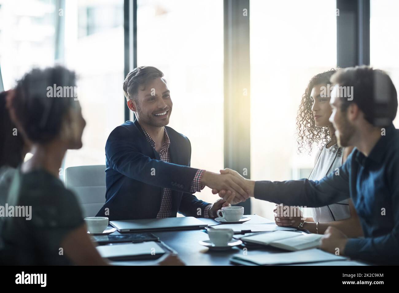 Welcome to our panel. Shot of a friendly businessman welcoming a new team member in the boardroom. Stock Photo