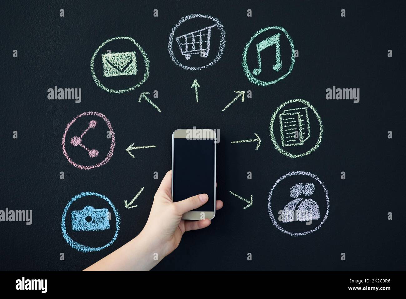 So many features to the phone. Shot of a person holding a cellphone surrounded by icons. Stock Photo