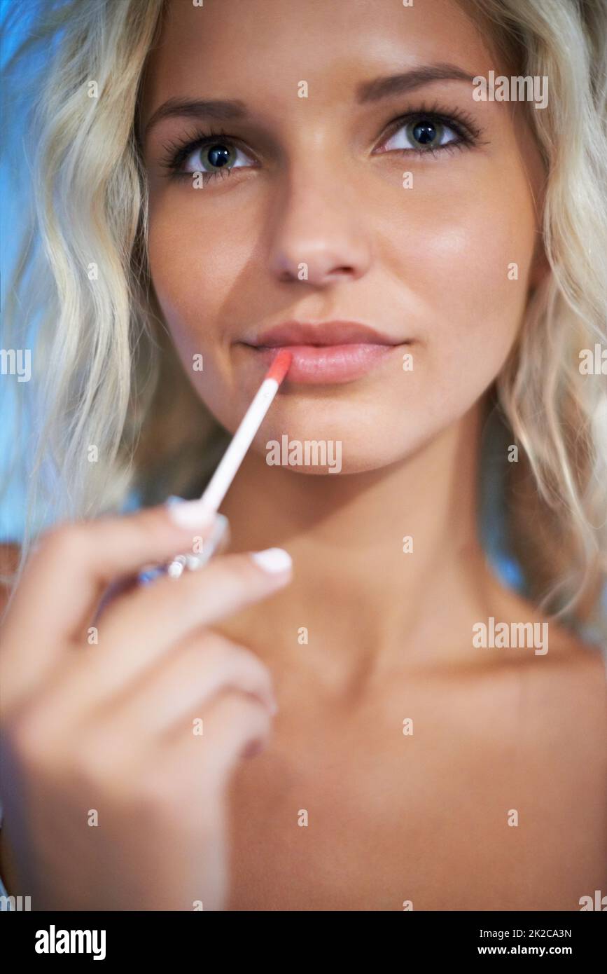 Perfect pout. Pretty young woman putting on some lipgloss. Stock Photo