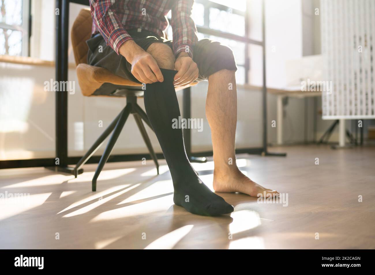 Man Putting On Medical Compression Stockings On Legs Stock Photo Alamy