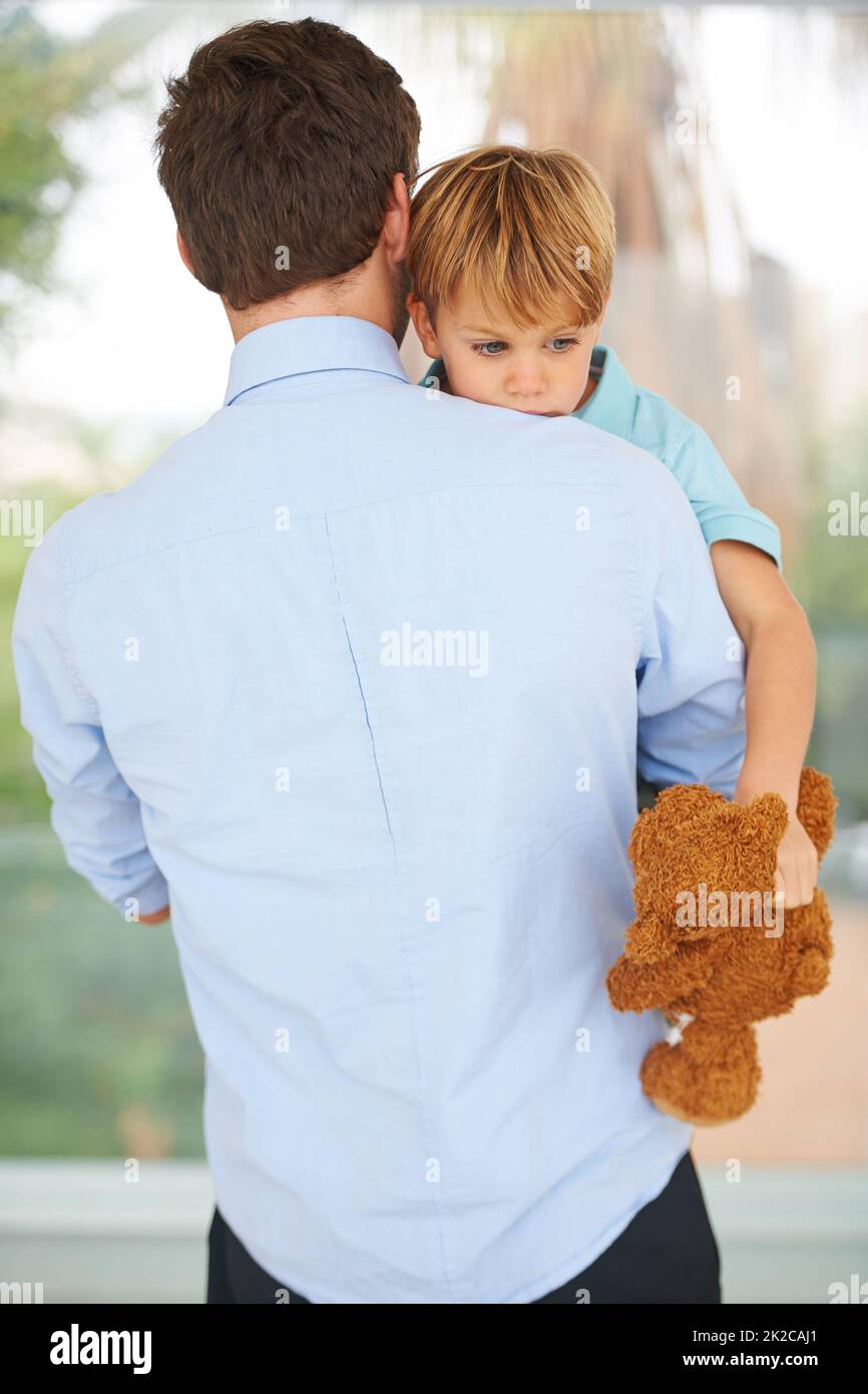 No, dont go. A little boy is upset that his father is leaving for work. Stock Photo