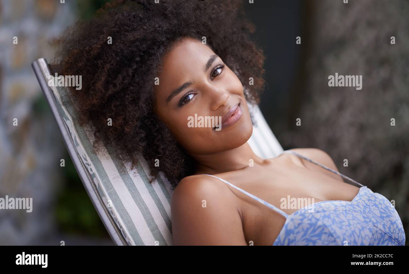 Relaxation is good for the soul. Attractive female relaxing outdoors on deck chair. Stock Photo