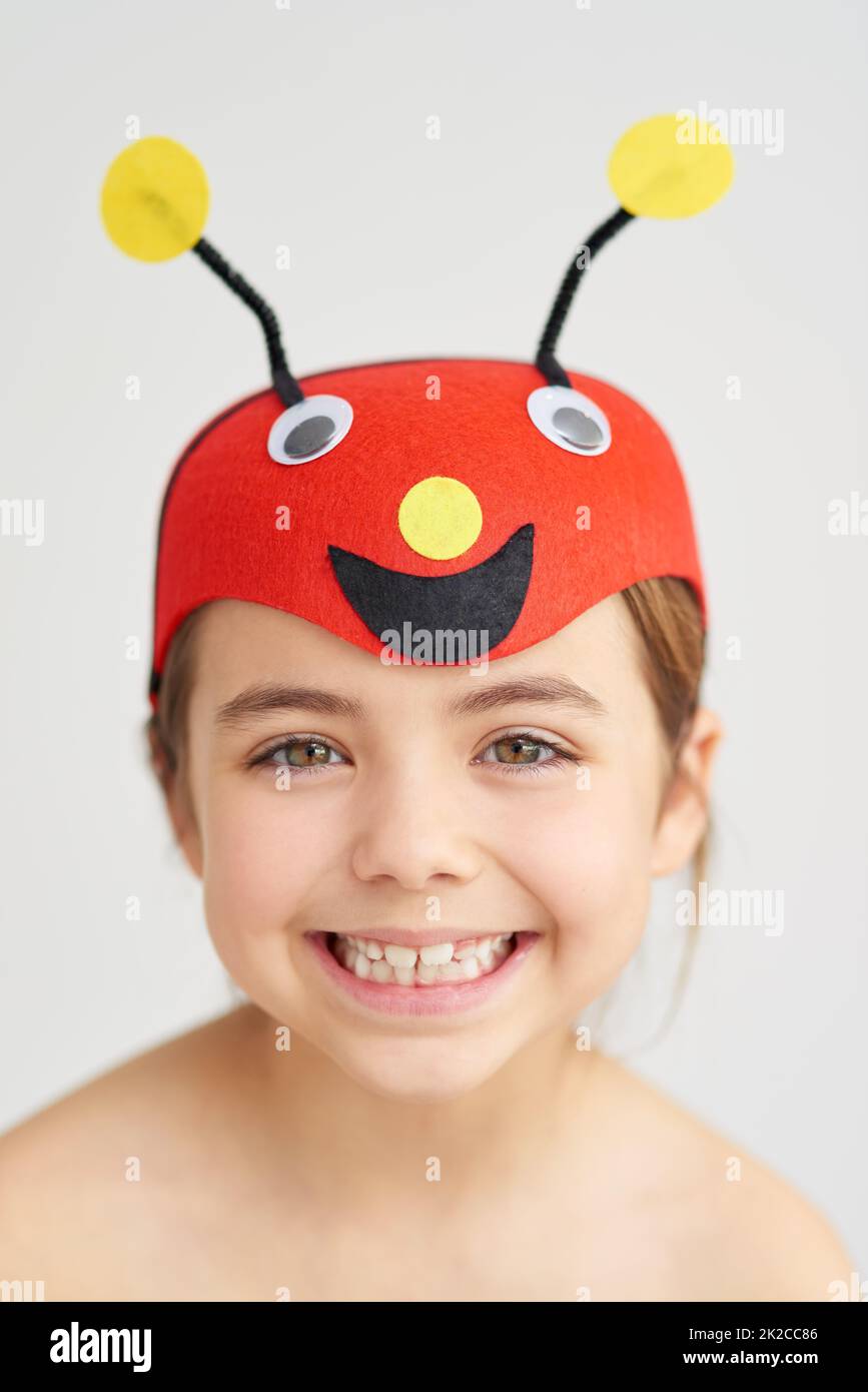 Precious little bug. Studio portrait of a cute little girl wearing a funny hat. Stock Photo