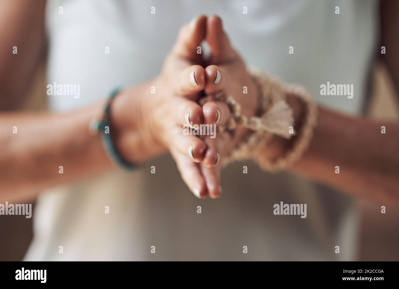 Balancing my chakras. Cropped shot of an unrecognizable woman standing with her palms together while meditating indoors. Stock Photo