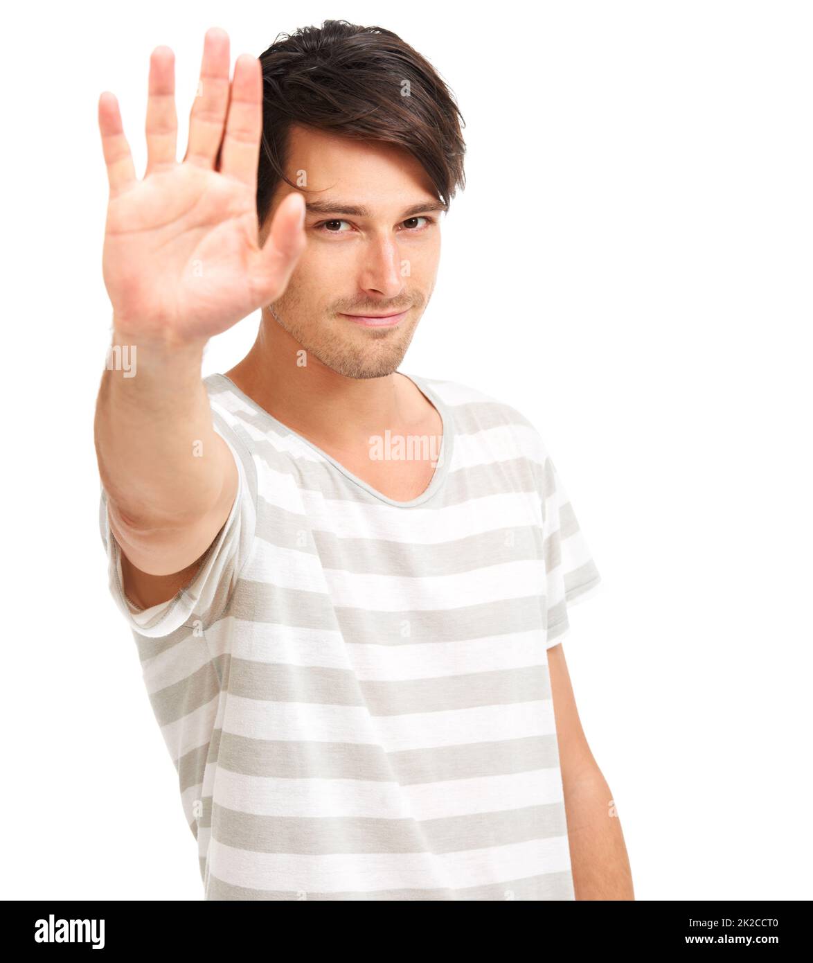 Give me five. Handsome trendy young man holding up his hand to the camera, isolated on white - copyspace. Stock Photo