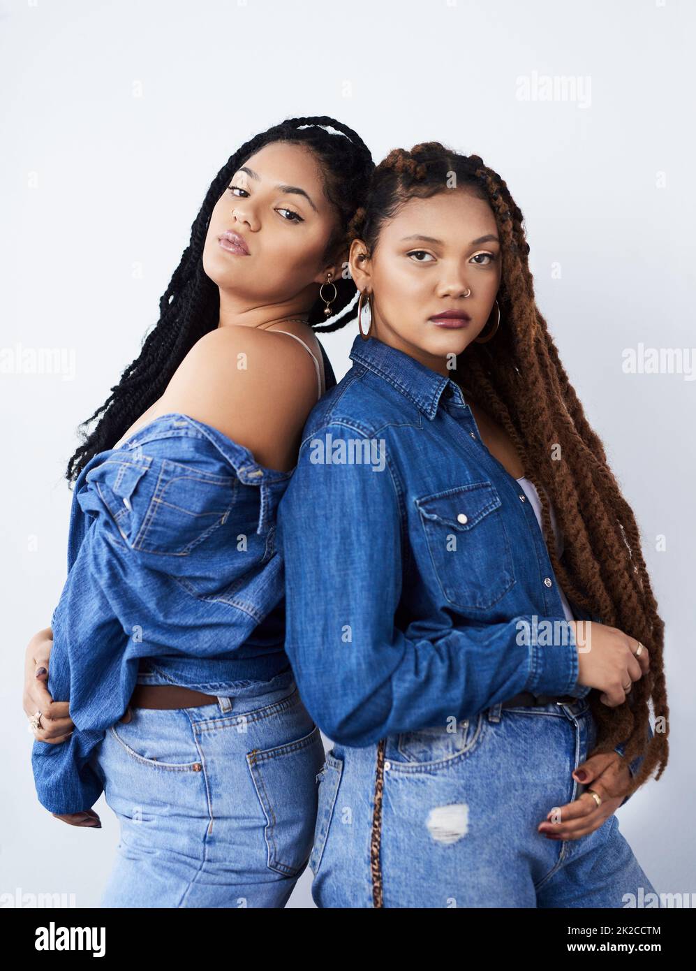Looking funky and fresh. Studio shot of two beautiful young women posing against a grey background. Stock Photo