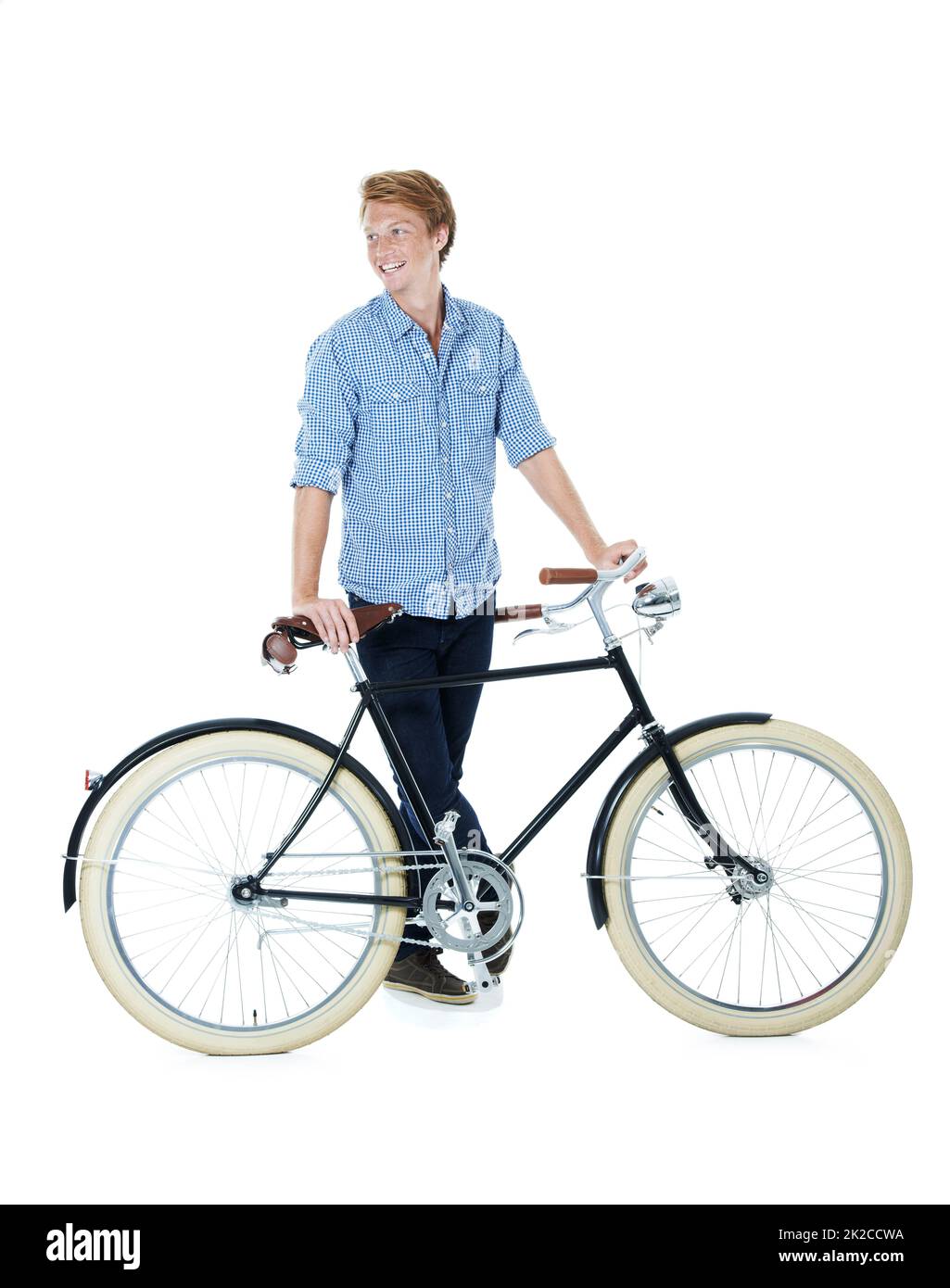 I take things slow. A handsome young red-headed man standing next to an old-fashioned bicycle. Stock Photo
