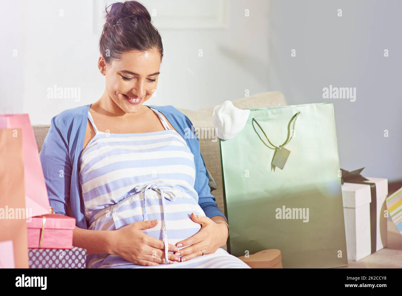Her baby is also enjoying the celebrations. Shot of a young pregnant woman at her baby shower. Stock Photo