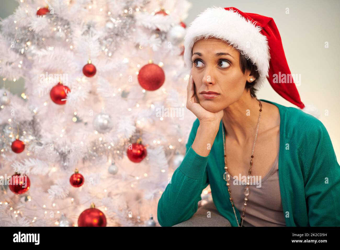 Whens santa going to arrive. Shot of a young woman looking displeased at Christmastime. Stock Photo