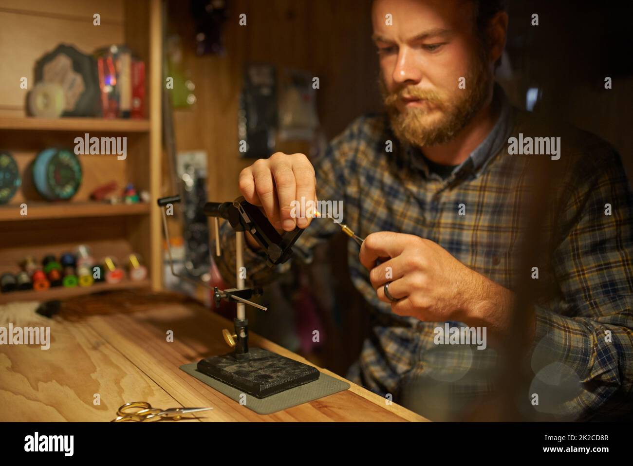 Creating the perfect fishing tackle. Shot of a man making fishing lures in his workshop. Stock Photo