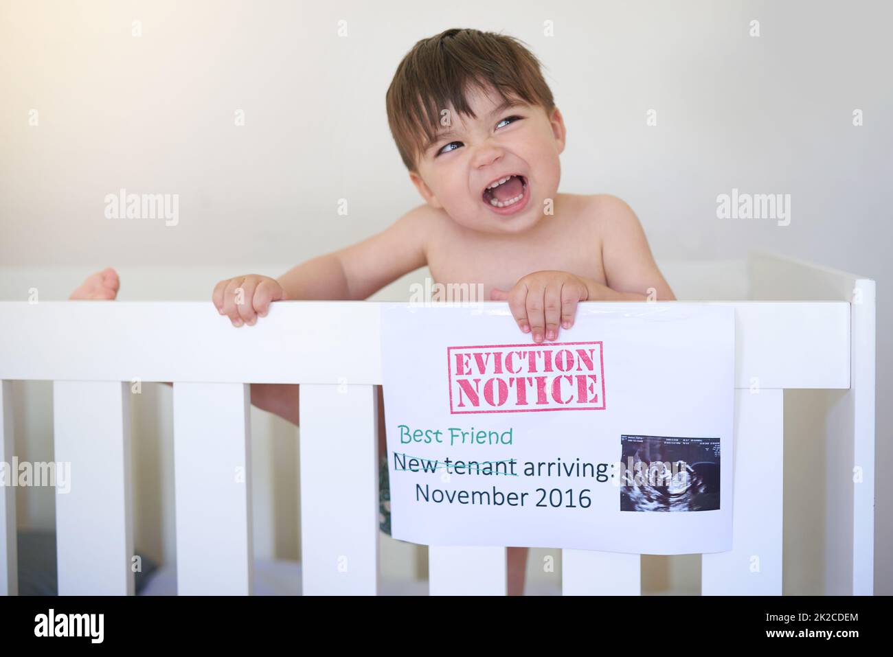 Making his objections heard. Shot of an unhappy baby boy crying while standing in his crib. Stock Photo