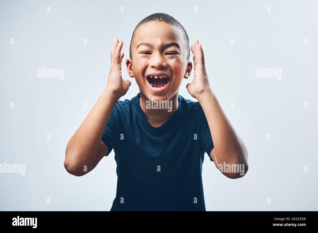 You guys...guess what. Studio shot of a cute little boy looking amazed ...