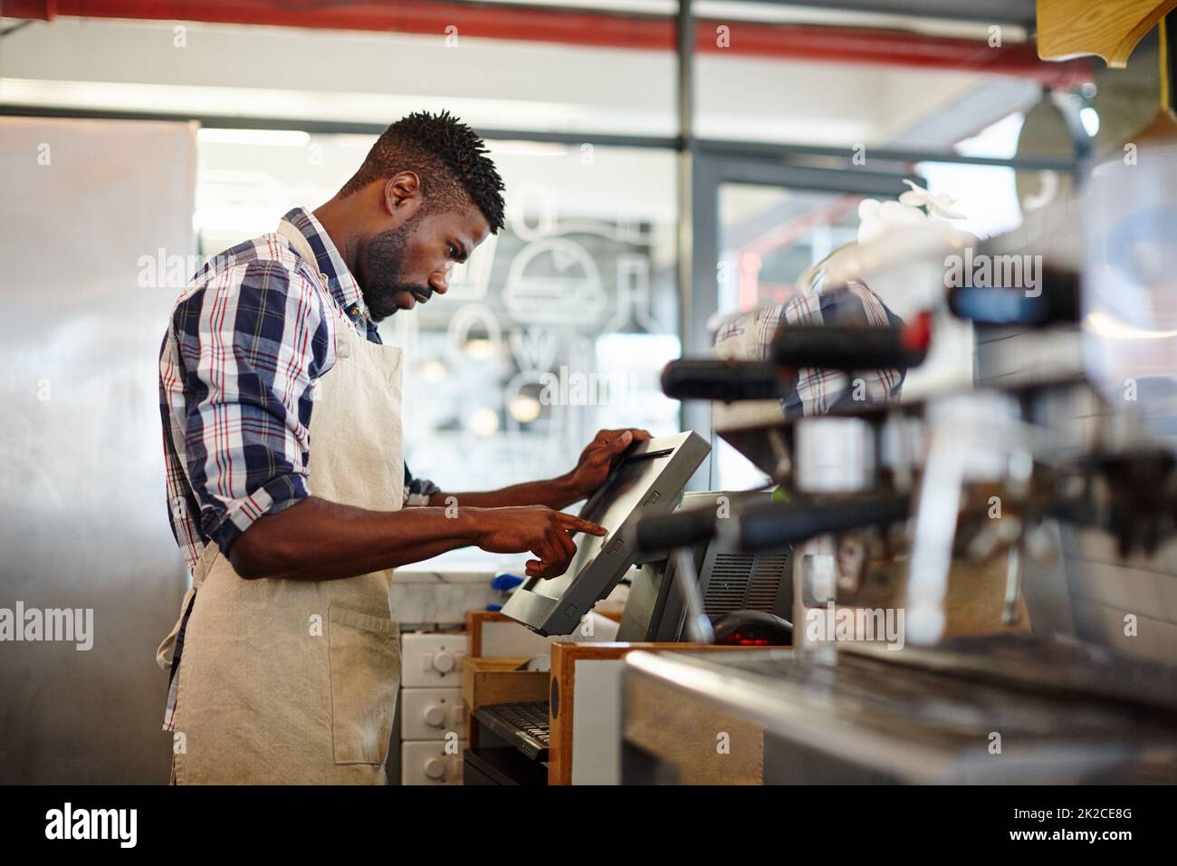 Busy day at the cafe. Cropped shot of a handsome male barista working in a coffee shop. Stock Photo