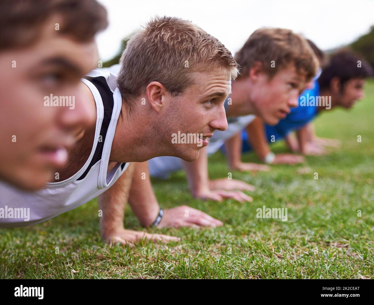 Doing the best they can. Shot of a group of young sportsmen training outdoors. Stock Photo