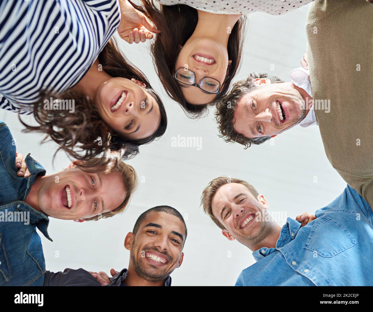 Part of a motivated team. Low angle shot of a team of people smiling down at the camera positively. Stock Photo