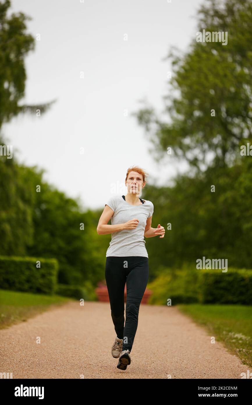 Running towards her fitness goals. Shot of a woman jogging down a