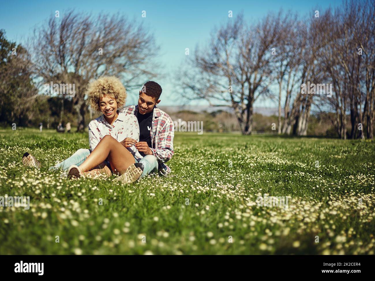 This is our favorite spot. Shot of a young couple spending quality time together at the park. Stock Photo
