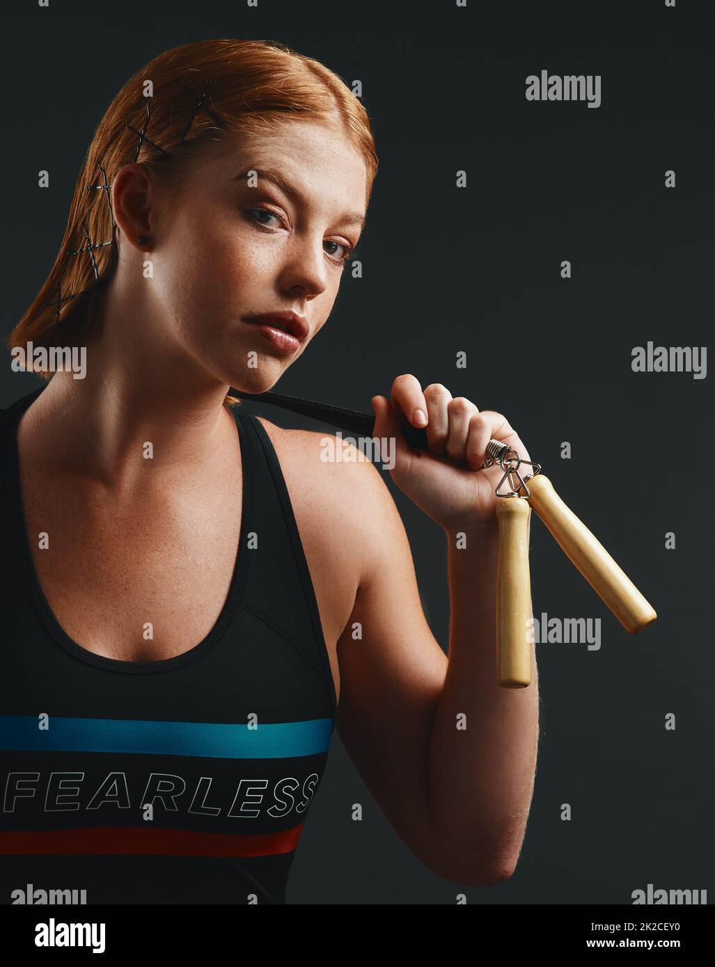 I skip right over challenges like its nothing. Studio portrait of a sporty young woman posing with a skipping rope against a black background. Stock Photo