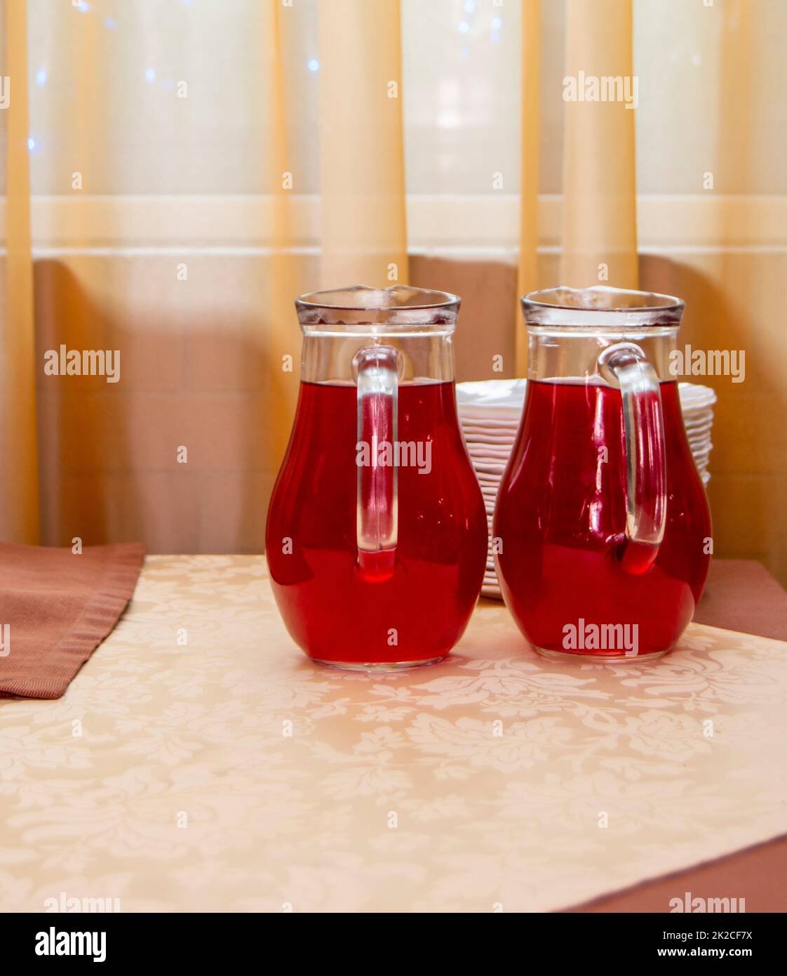 Two glass jugs of cranberry juice on the table Stock Photo