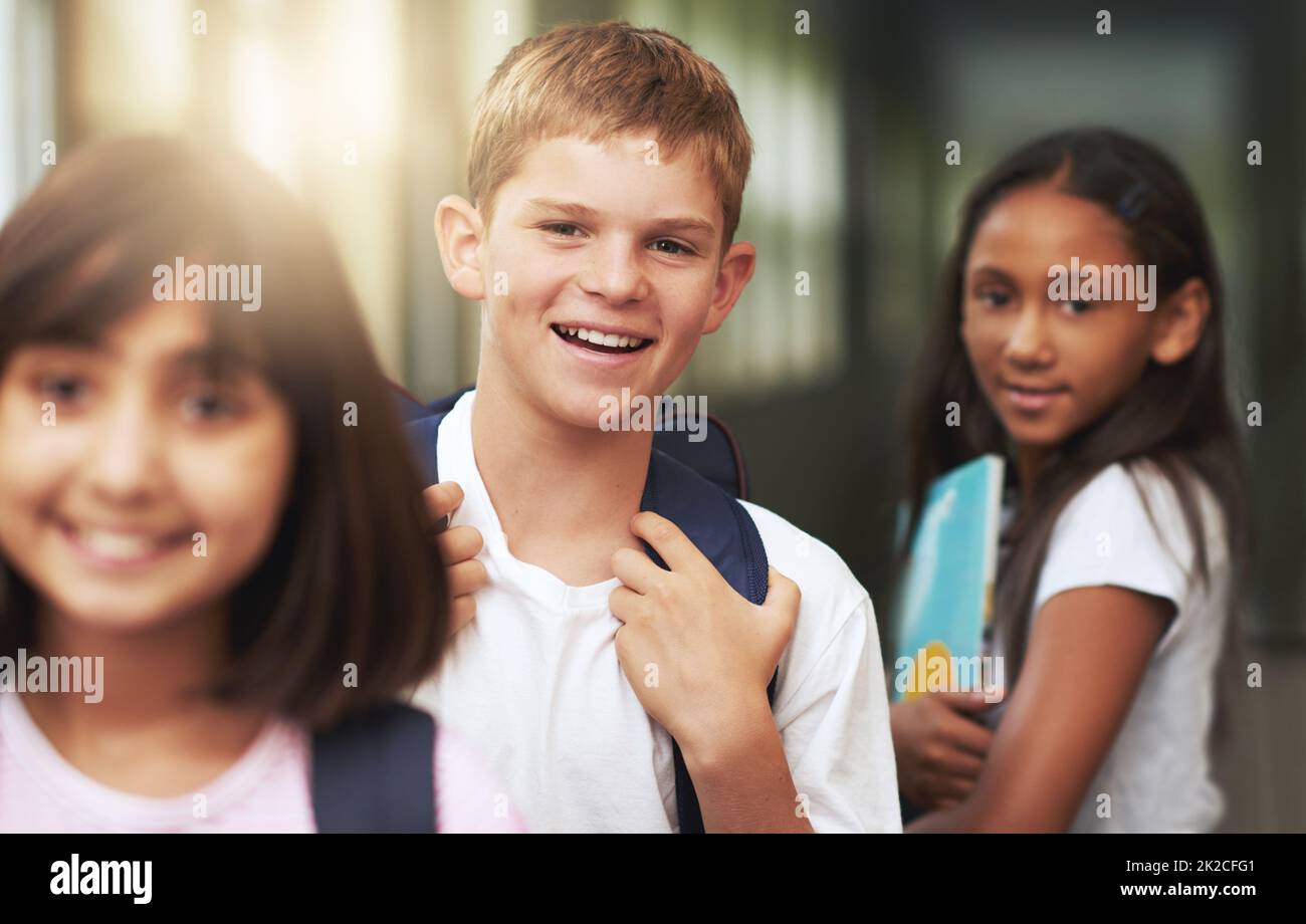 The time to learn is now. Portrait of elementary students standing in a school hallway. Stock Photo