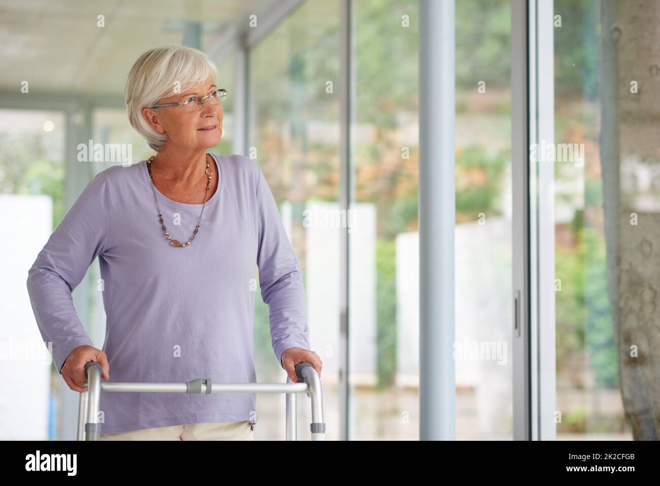 Every reason to be positive. Shot of a senior woman using an orthopedic walker indoors. Stock Photo