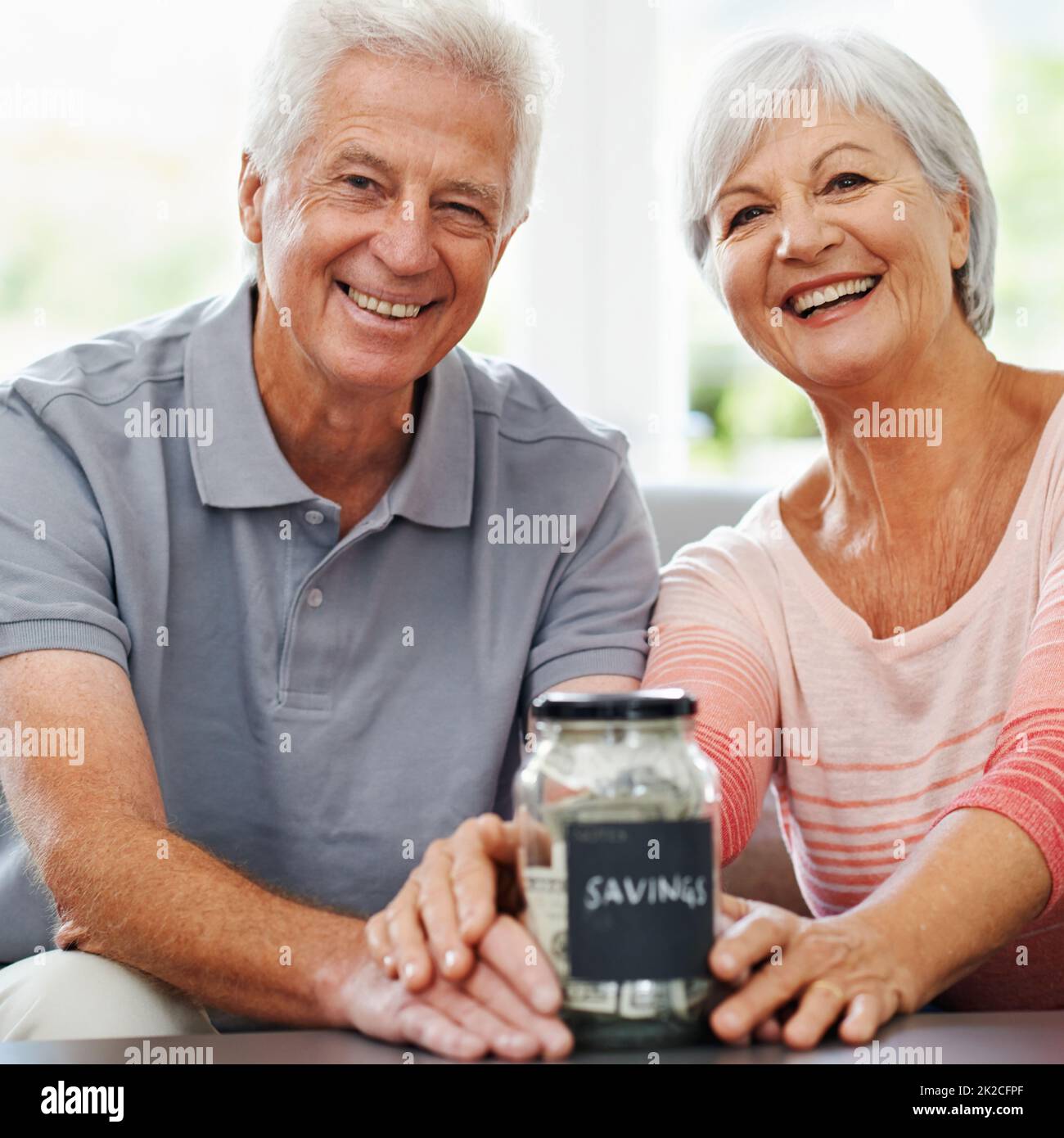 A jar of happiness and security. Shot of a senior couple posing with