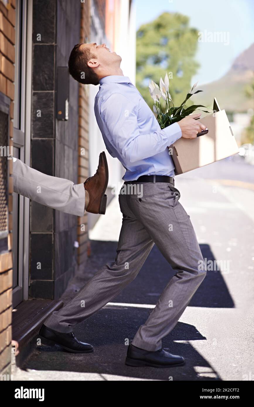 Not even a thank you for all your hard work. Shot of a young businessman being kicked out of his office. Stock Photo