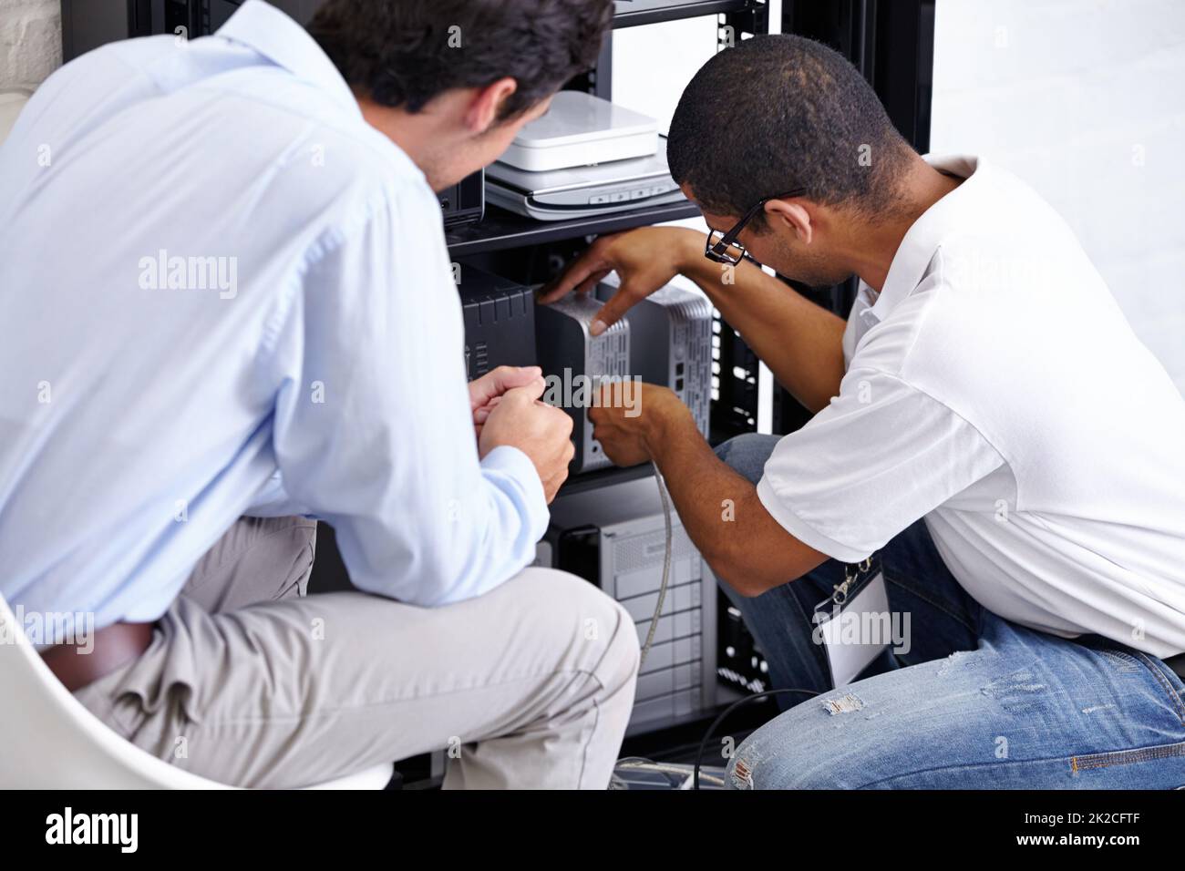 Hi tech service. A technician fixing his clients electronic device. Stock Photo
