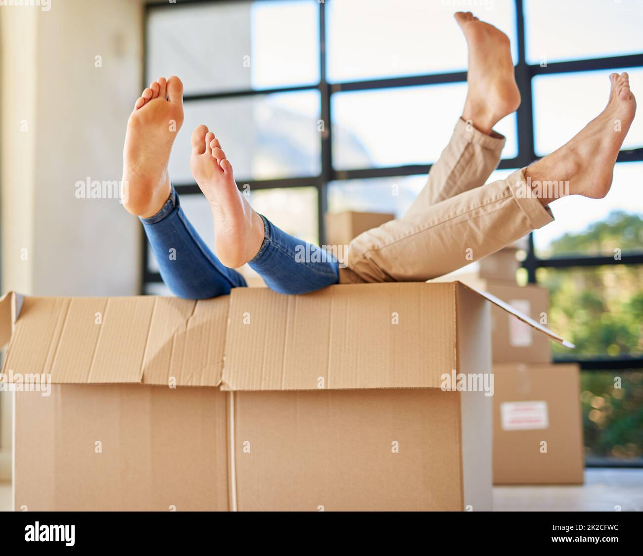 Handle with care. Shot of an unidentifiable young couple lying in a box