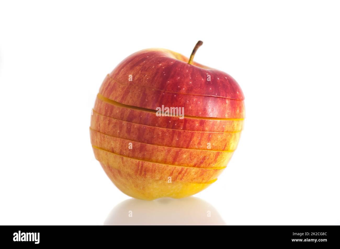 Close-up on a white background isolated red bright, juicy fresh apple sliced into slices. Stock Photo