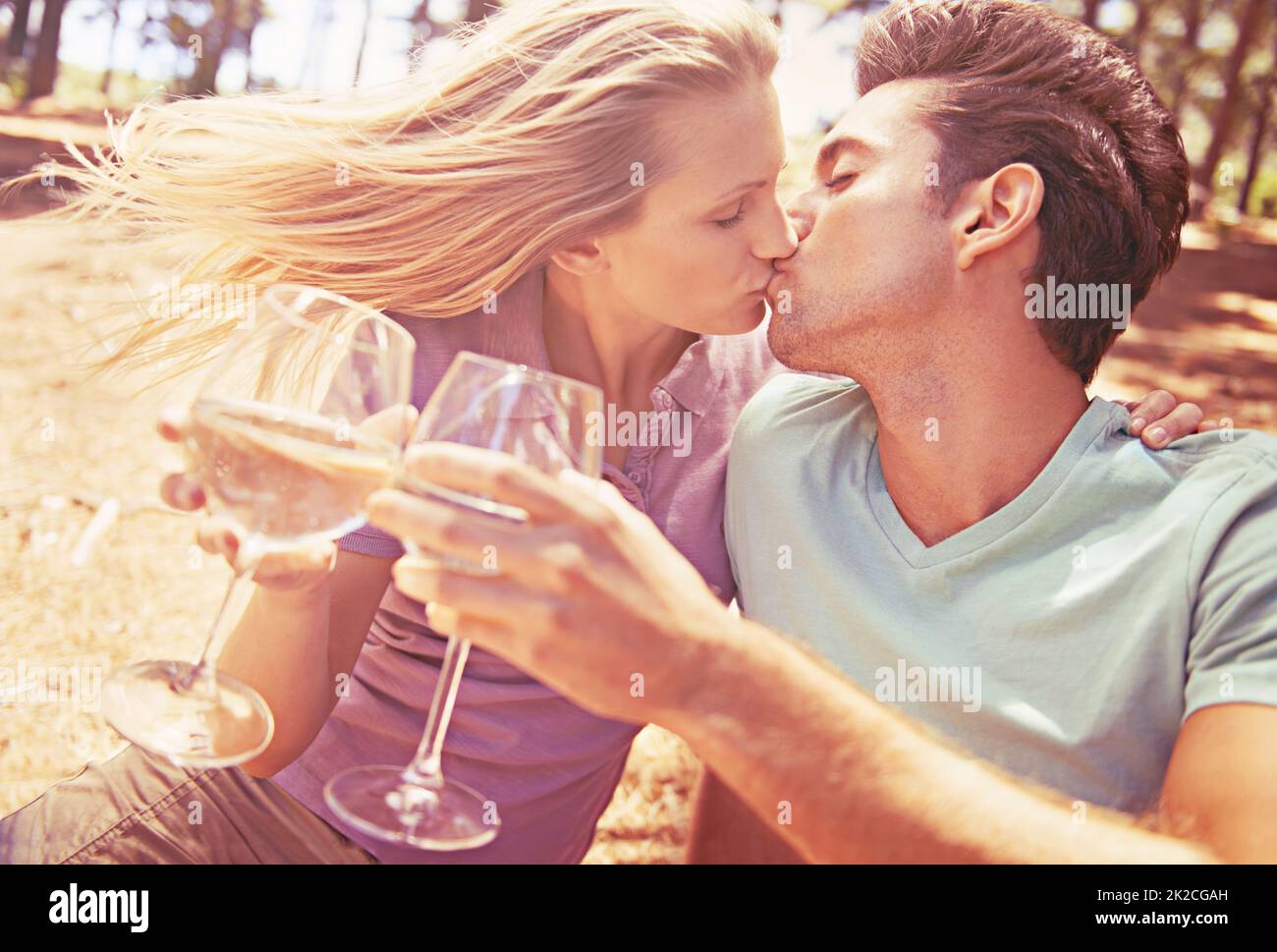 Celebrating Love Shot Of A Beautiful Young Couple Kissing And Drinking Wine Outdoors Stock 