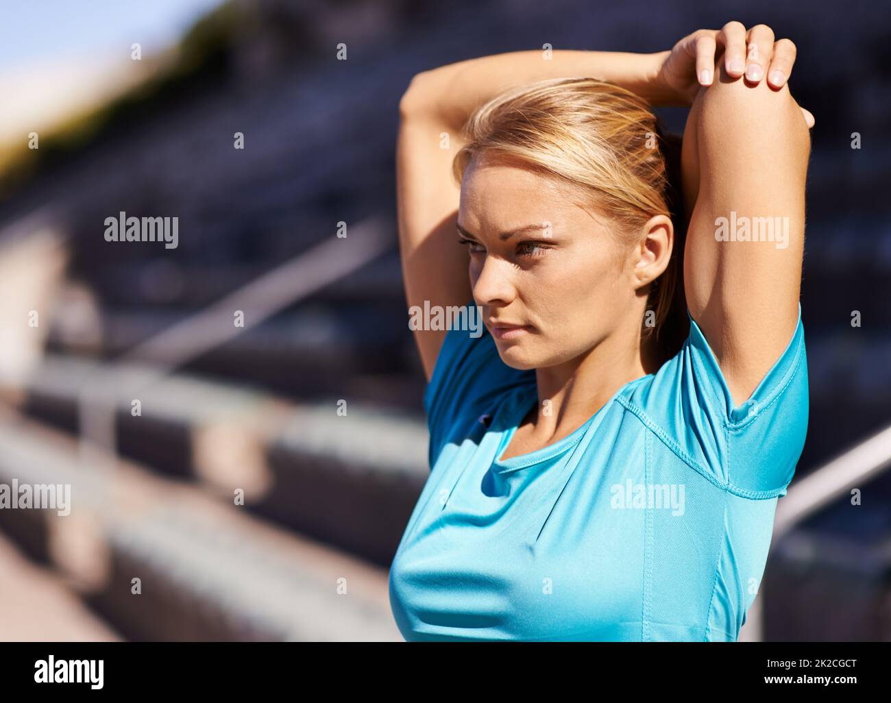 Ready for a race. Shot of an attractive young runner stretching out on the track. Stock Photo