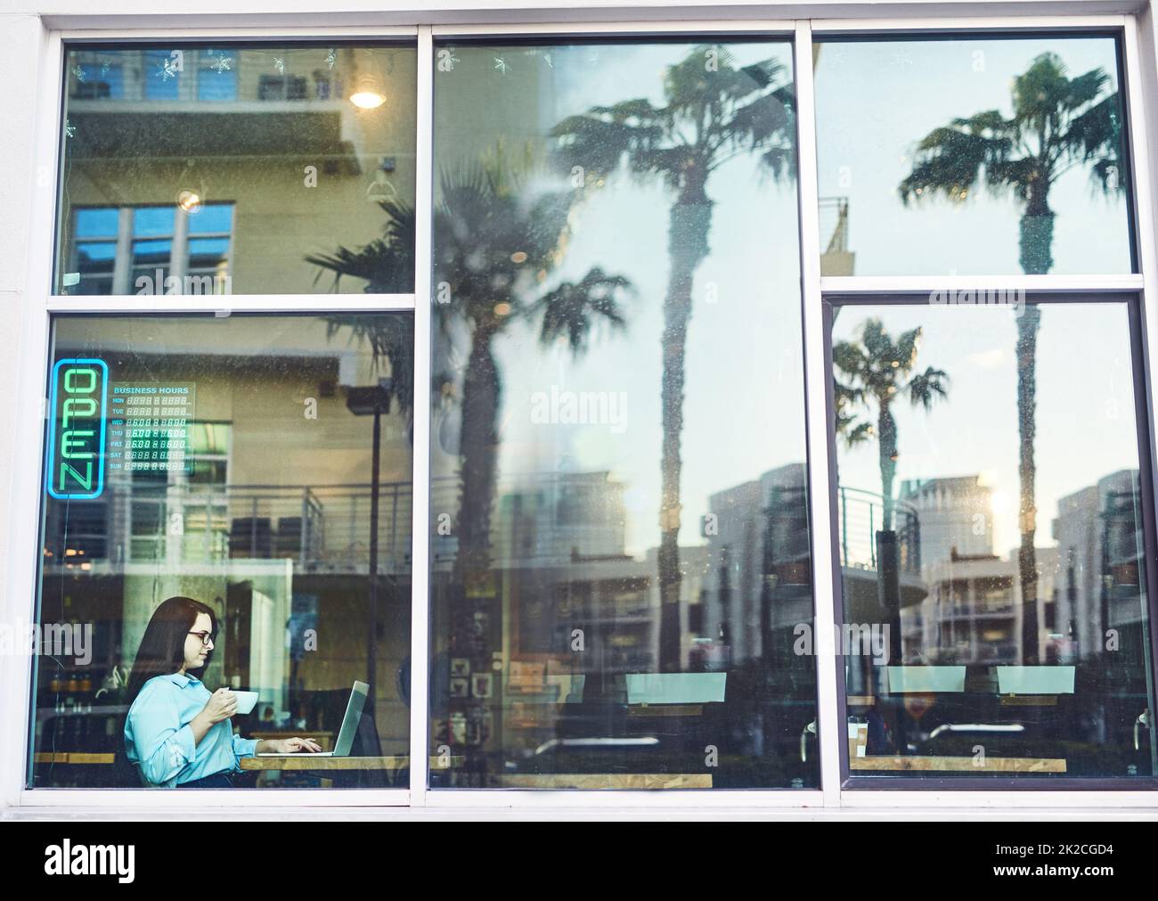 The best cafe on the block. Shot of a young woman using a laptop in a cafe. Stock Photo