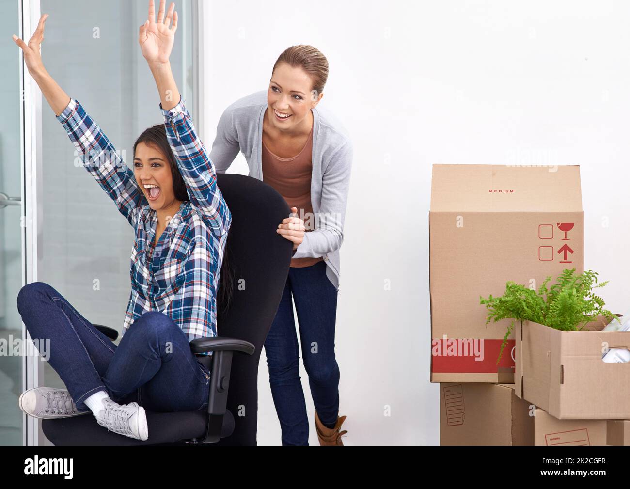 The excitement of moving is in the air. Shot of two female entrepreneurs moving into a new office. Stock Photo