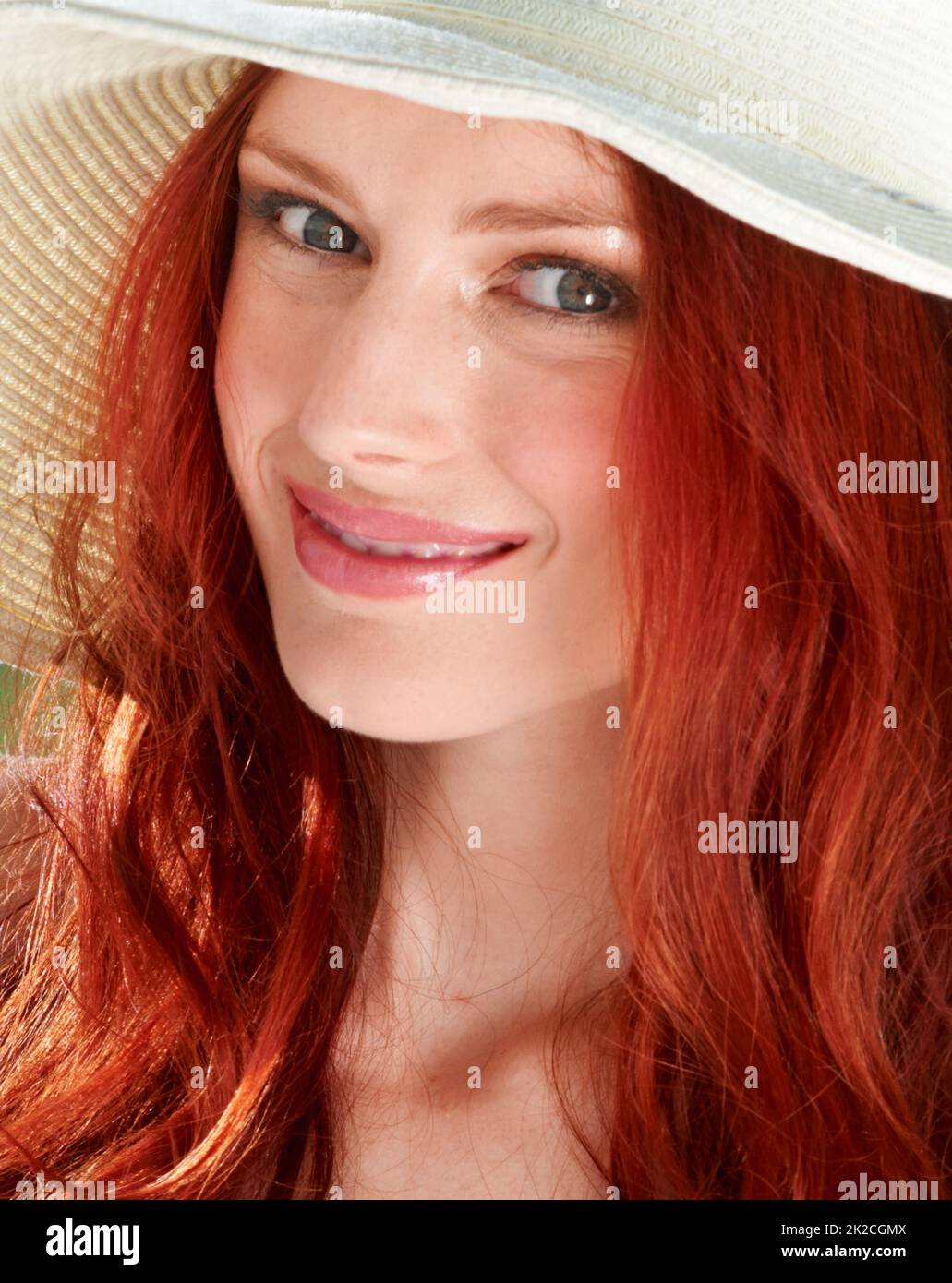 Fiery summer. A young redheade woman wearing a sunhat. Stock Photo
