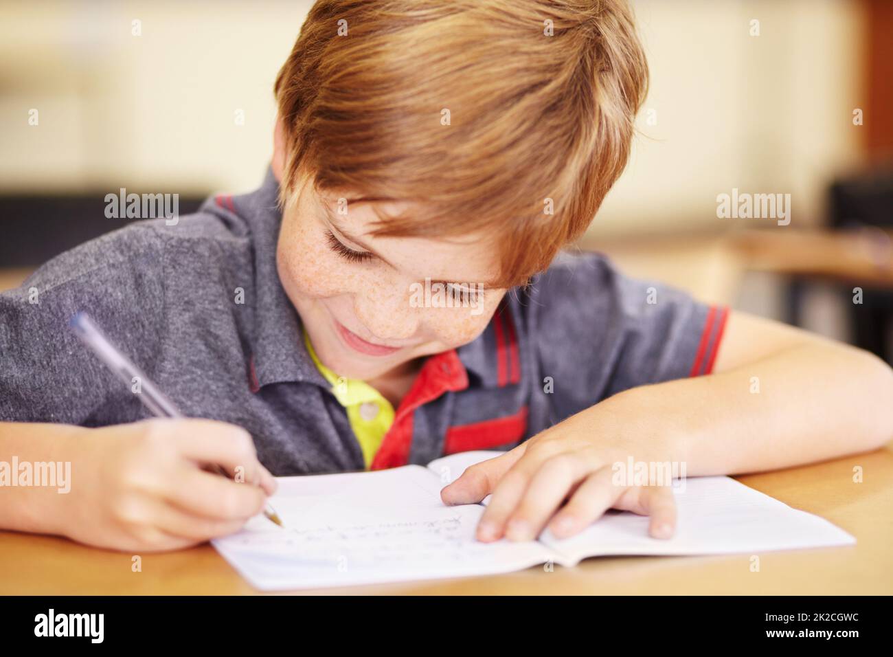Happy to do his homework. A cute little boy doing his homework in class