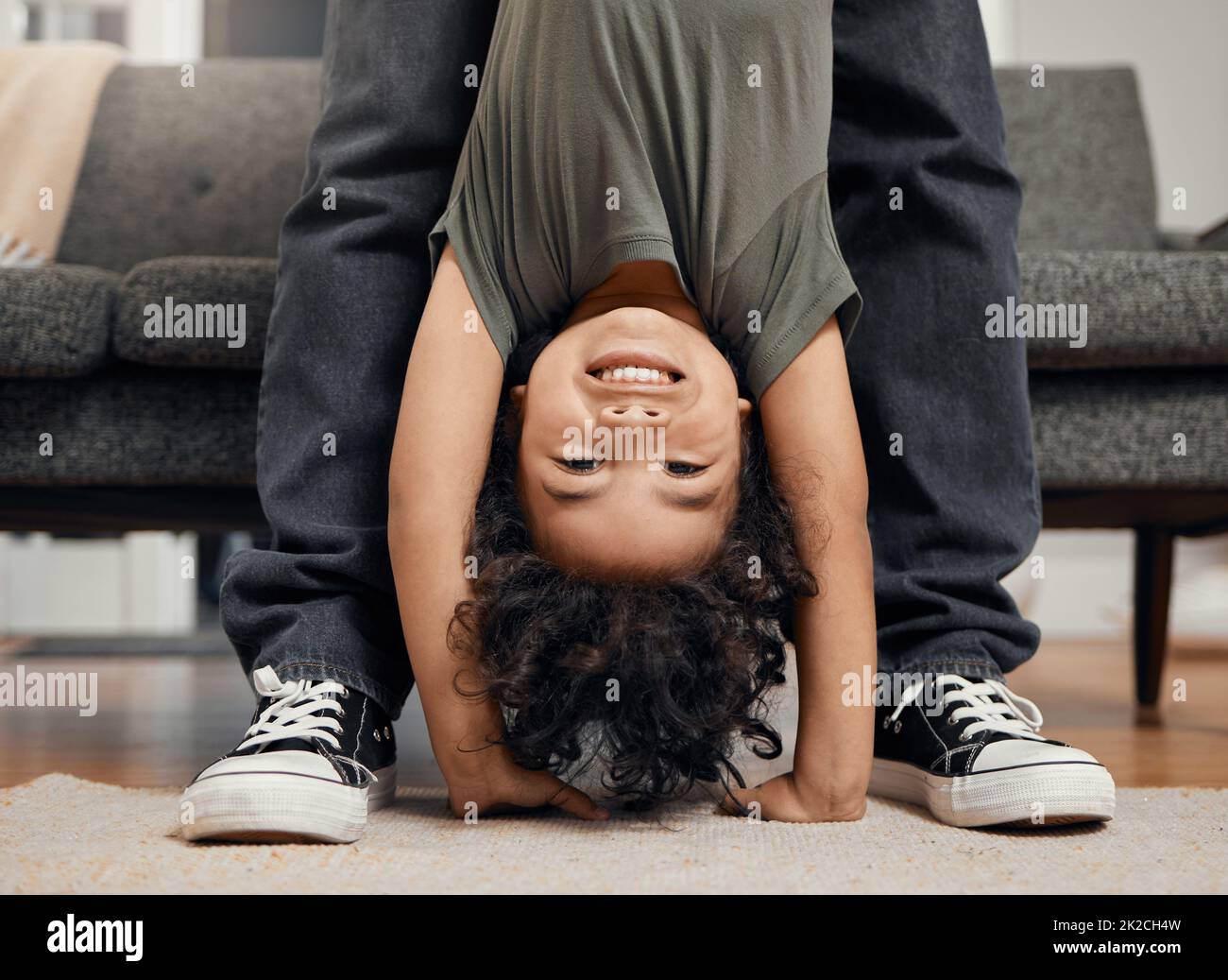 Everyone has a fun side. Shot of an adorable little boy being held upside down. Stock Photo