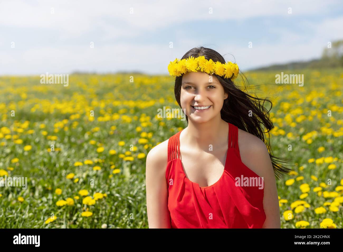 Laughing young girl posing in dandelion meadow. Stock Photo