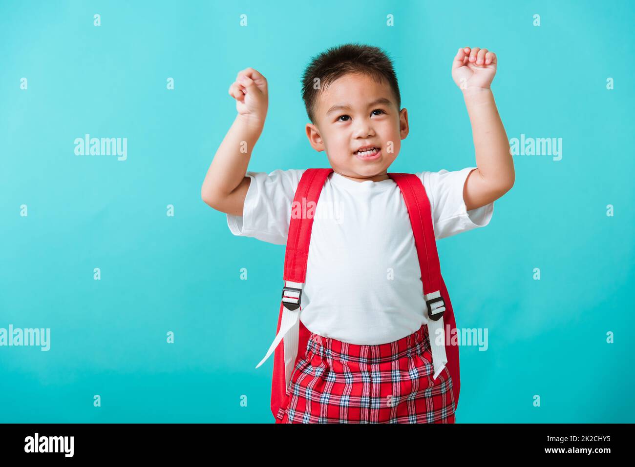 child boy in uniform smile raise hands up glad when go back to school Stock Photo
