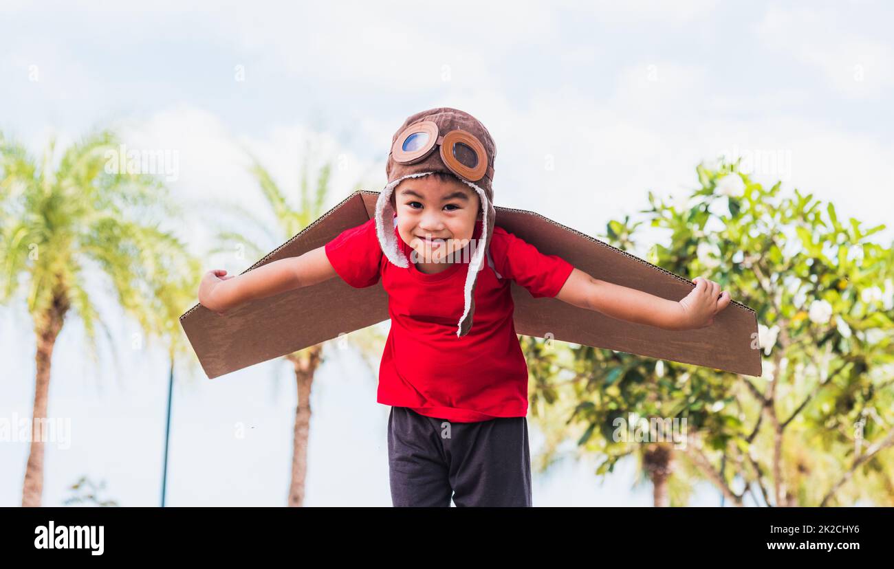 kid little boy smile wear pilot hat and goggles play toy cardboard