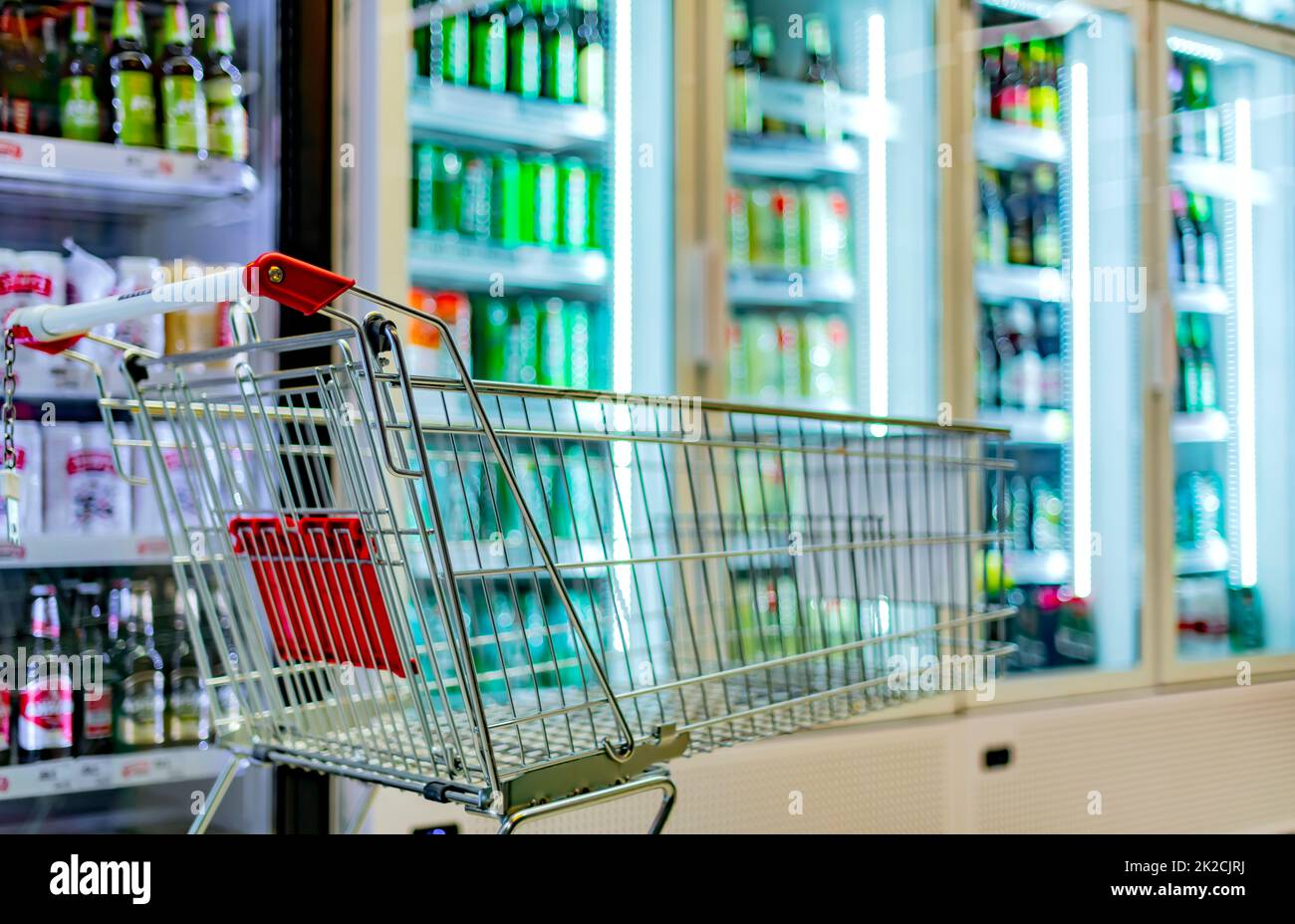 A shopping cart by a store shelf in a supermarket Stock Photo