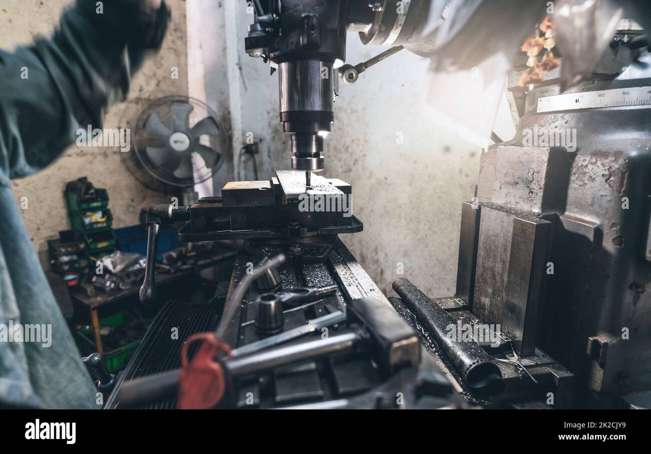 Selective focus on milling machine. Blurred worker is working on