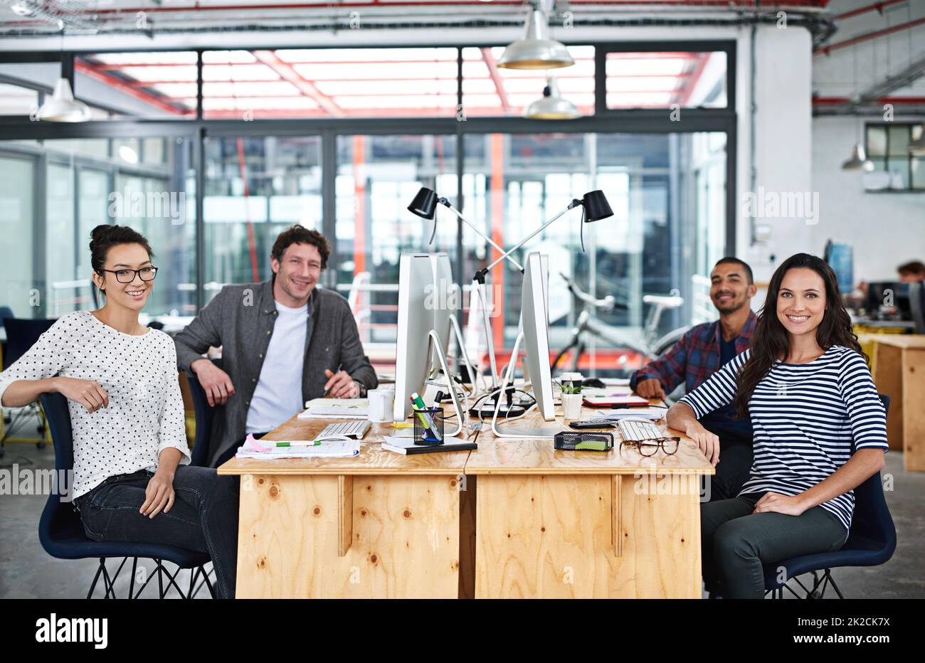 Make creativity a job. Portrait of a group of young office workers sitting at their work stations. Stock Photo
