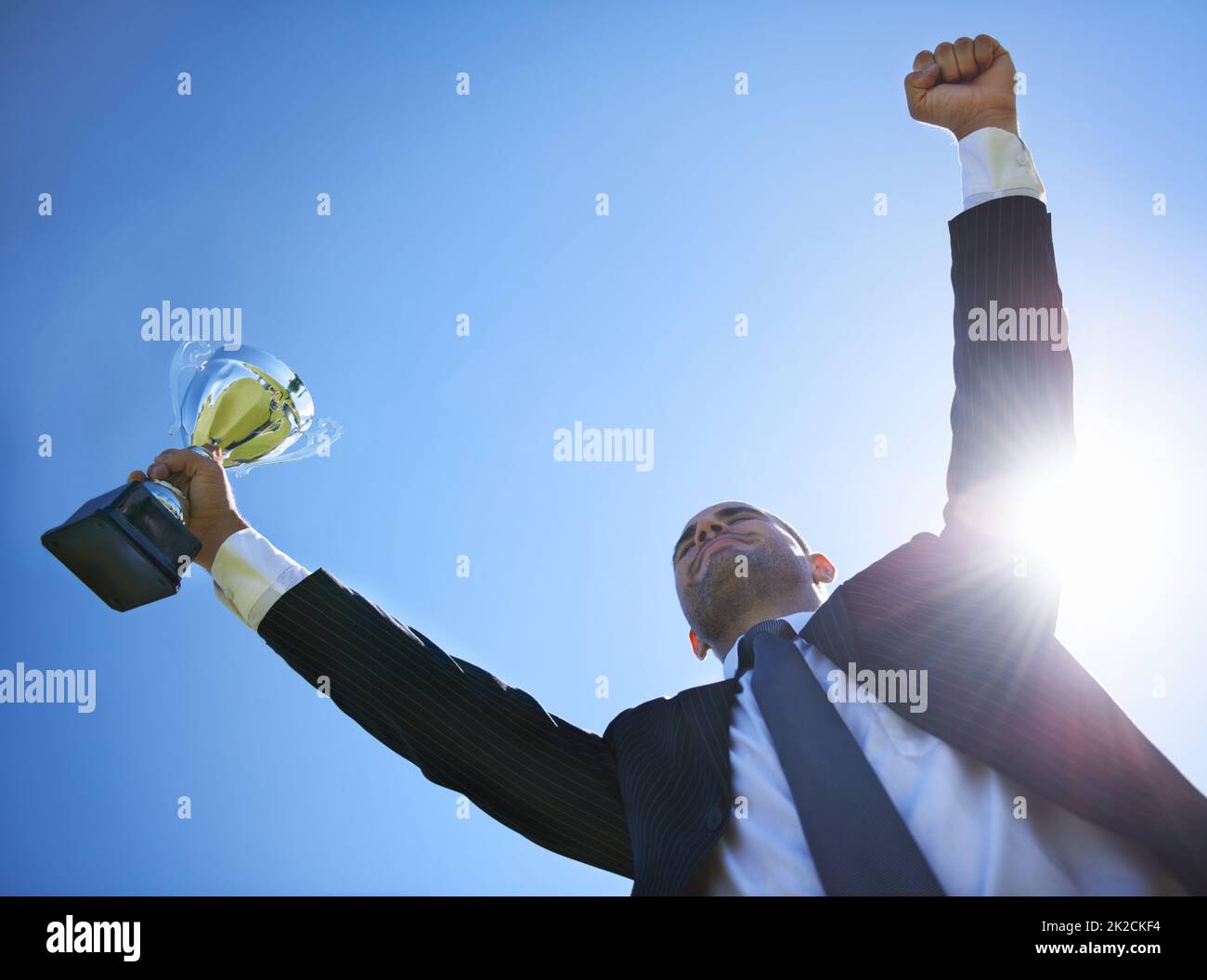 Corporate success. Low angle view of a businessman holding a cup. Stock Photo