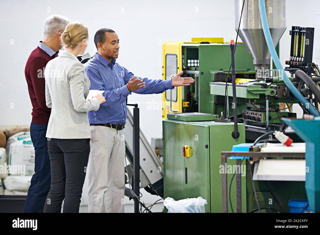 Managing the factory floor. Shot of a managers inspecting factory machinery. Stock Photo